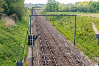 Tren rayları bulutlu gökyüzüyle ufukta kayboluyor.