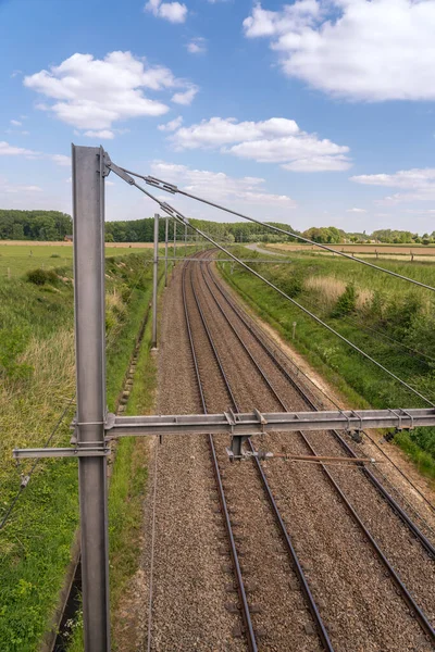 Tren rayları bulutlu gökyüzüyle ufukta kayboluyor.