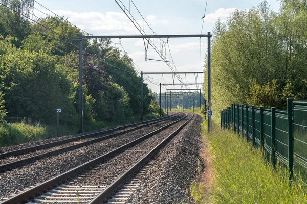 Tren rayları bulutlu gökyüzüyle ufukta kayboluyor.
