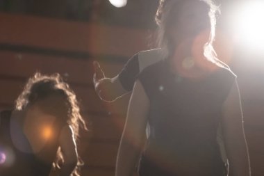 Dansçılar mırıldanır, doğaçlama yapar, detay verir. Arkaplan ışığı bulanıklığı