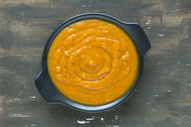 Ahşap arka planda siyah tabakta kabak püresi