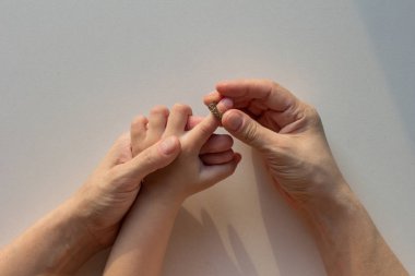 Masaj yüzüğünü takan kadın elleri beyaz arka planda Su-Jock 'un çocuk parmağına.