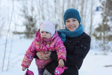 Orta yaşlı bir kadın ve bir çocuğun kış parkındaki portresi.