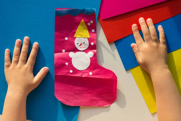 Vista superior de la aplicación con el muñeco de nieve hecho por manos de niños y niños —  Fotos de Stock