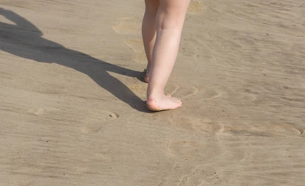 Gyermek láb mezítláb sétál a homokos parton — Stock Fotó