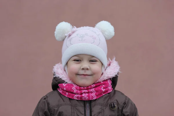 Portret van kind in warme doek in de winter seizoen kijken opzij op de paarse achtergrond — Stockfoto