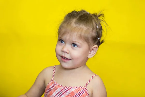 两岁白种人小女孩的画像 带着顽皮的黄色背景 看一边看 — 图库照片