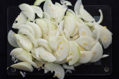 Siyah arkaplanda yarım boy soğan şeritleri kesilen üst görünüm