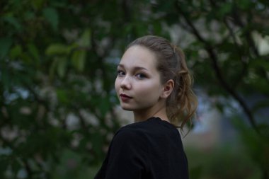 Yaz zamanı kameraya bakan genç bir kızın portresi