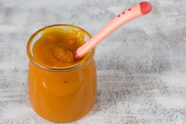 Cam kavanozda kabak püresi ve beyaz arka planda kaşık.