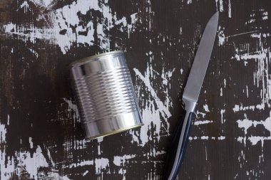 Konserve kutusu ve ahşap arka planda sıradan bir bıçak.