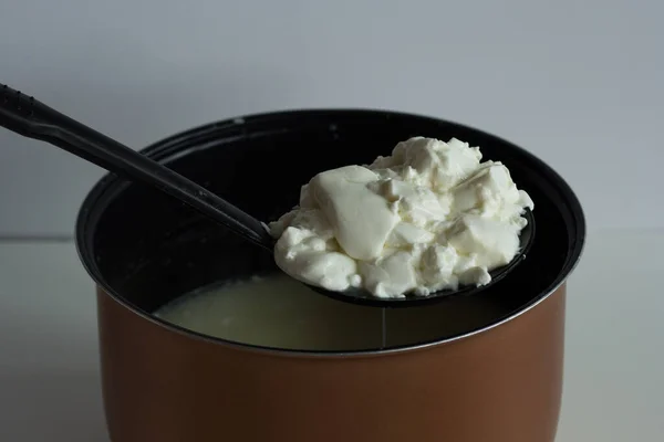 Обезжиренная смесь с сыром, творогом или греческим йогуртом, берущая его из кастрюли, чтобы положить на вафельное полотенце или сформировать — стоковое фото