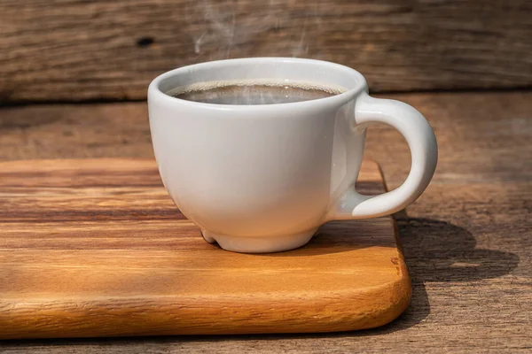 Eine weiße Tasse heißen Kaffee auf Holzgrund. — Stockfoto