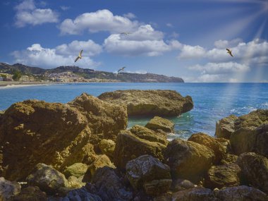 Bir sabah kayalıklardan denize bakarken arka planda La Herradura köyünün ucu.
