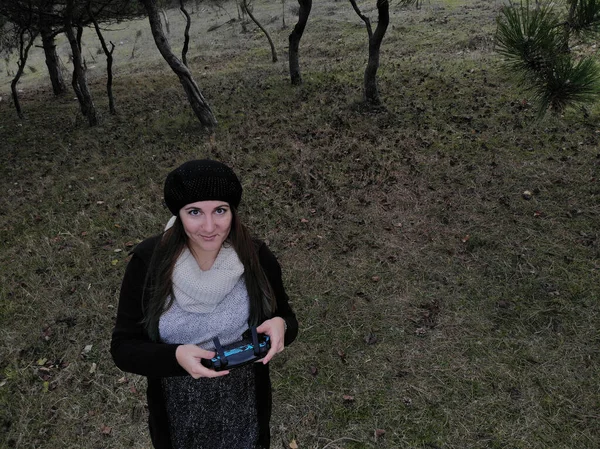 Piloto de drones hembra sosteniendo un controlador de drones en un bosque durante — Foto de Stock