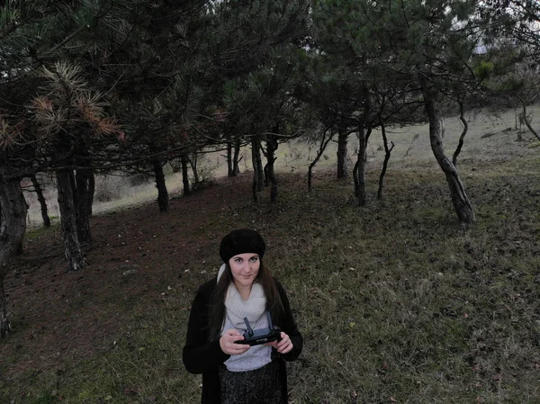 Piloto de drones hembra sosteniendo un controlador de drones en un bosque durante — Foto de Stock