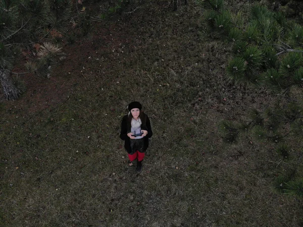 Piloto de drones hembra sosteniendo un controlador de drones en un bosque durante — Foto de Stock