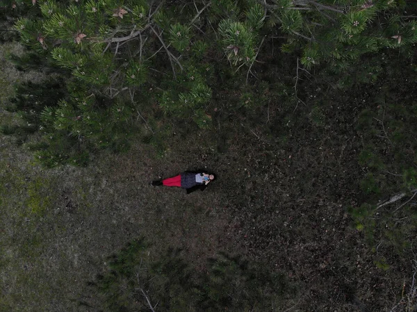 Vista superior de una hembra con pantalones rojos acostada en un bosque durante la victoria — Foto de Stock