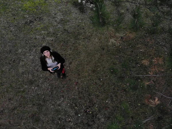 Piloto de drones hembra sosteniendo un controlador de drones en un bosque durante — Foto de Stock