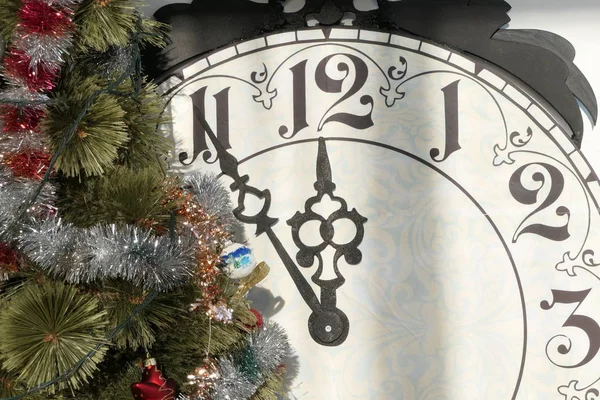 Gece yarısını gösteren klasik saat ve dekorlu bir Noel Ağacı