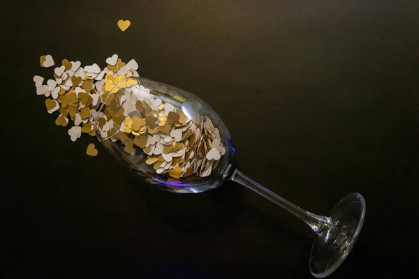 Arany papír Szívek spreadin egy borospohár egy fekete Backgr — Stock Fotó