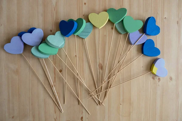 Разноцветные пенополистироловые сердца на палочках на деревянном фоне — стоковое фото