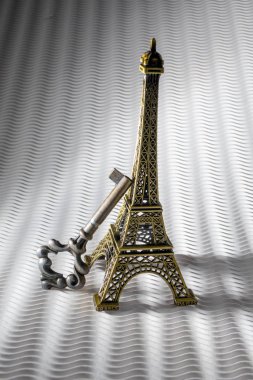 Beyaz bir arkaplanda izole edilmiş Vintage Property Key ve Eiffel Tower Miniature