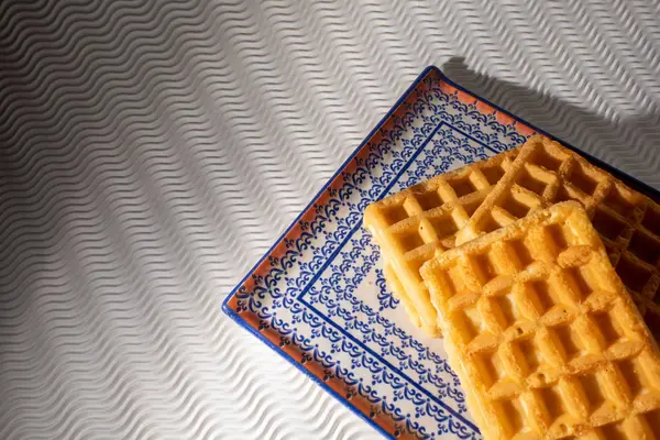 Vista próxima de waffles em uma placa azul isolada em um backgr branco — Fotografia de Stock