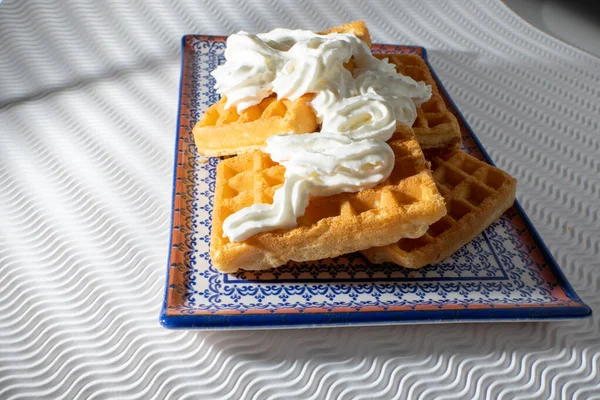 Vista Próxima Waffles Com Creme Uma Placa Azul Isolada Fundo — Fotografia de Stock