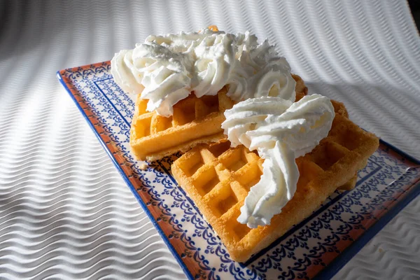 Vista Próxima Waffles Com Creme Uma Placa Azul Isolada Fundo — Fotografia de Stock