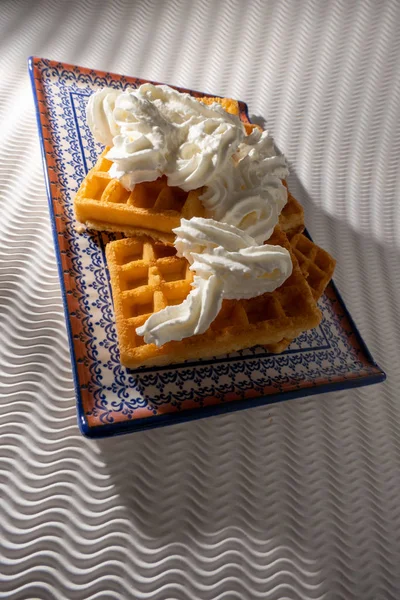 Vista Próxima Waffles Com Creme Uma Placa Azul Isolada Fundo — Fotografia de Stock