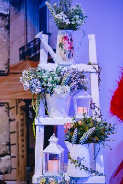 Çiçekler, mumlar ve ahşap kutularla taze, mavimsi dekorasyon.