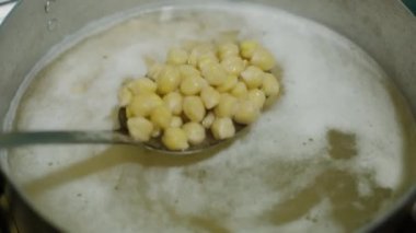 Nohutları kaynayan suda kaşıkla karıştırmak, yavaş çekim videosu
