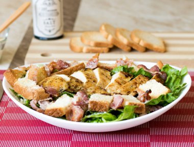 Kızarmış tavuklu sezar salatası, parmesan peyniri ve tost.