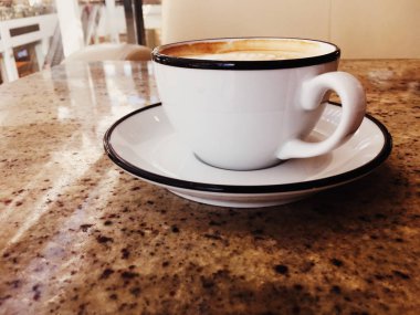 Kafeteryada kahvaltı için Cappuccino, pa masada kahve fincanı