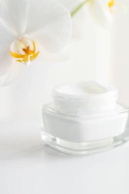 Yüz kremi kavanozu ve orkide çiçeği, nemlendirici cilt 