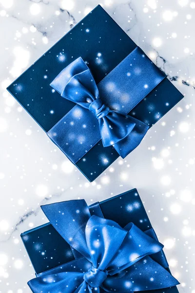 Zima wakacje pudełko z niebieskim jedwabnym łukiem, śnieg brokat na marb — Zdjęcie stockowe