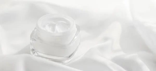 Gezicht crème moisturizer pot op zijde achtergrond, hydraterende huid — Stockfoto