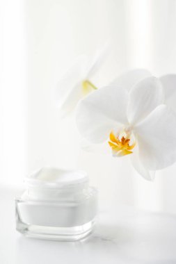Yüz kremi kavanozu ve orkide çiçeği, nemlendirici cilt 