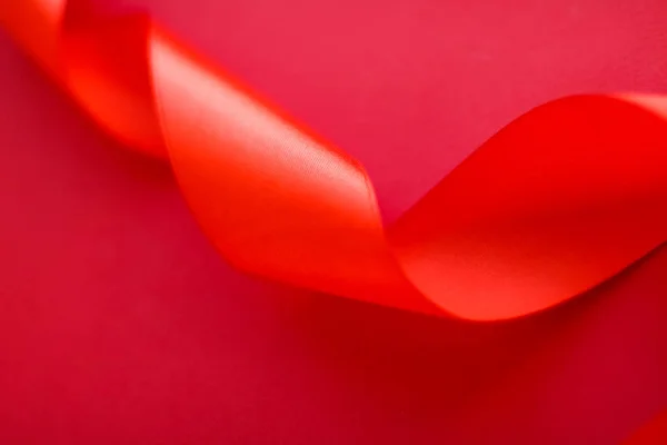 Abstrakcyjna wstążka jedwabna kręcona na czerwonym tle, ekskluzywny luksus b — Zdjęcie stockowe