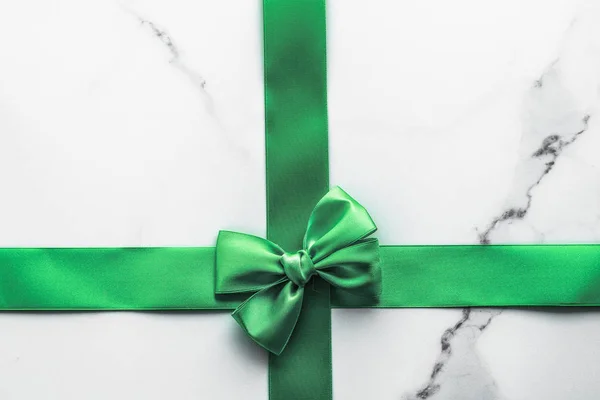 Green silk ribbon and bow on marble background, St Patricks day