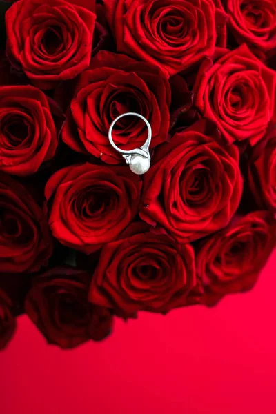 Hermoso anillo de perlas de oro blanco y ramo de rosas rojas, de lujo — Foto de Stock