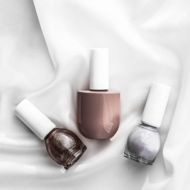 İpek arka planda oje şişeleri, Fransız manikür ürünleri.