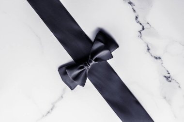 Siyah ipek kurdele ve yay mermer arka planda, yatık