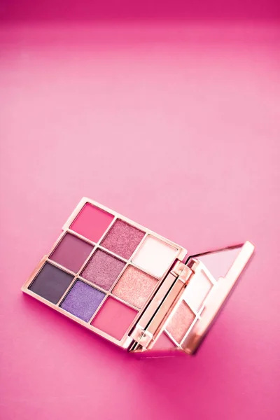 Eyeshadow palette and make-up brush on pink background, eye shad