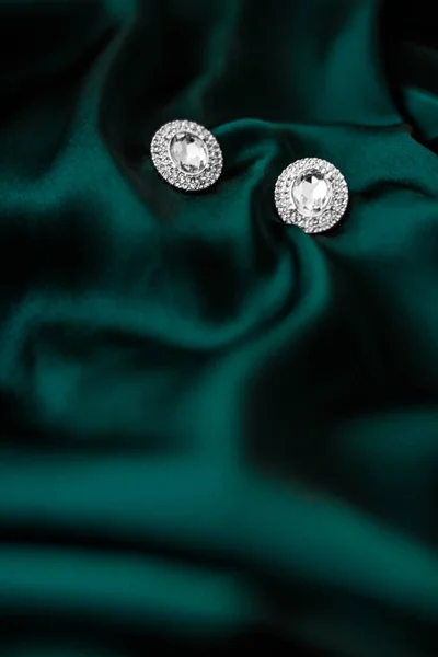 Pendientes de diamantes de lujo en seda verde esmeralda oscura, glamour navideño —  Fotos de Stock