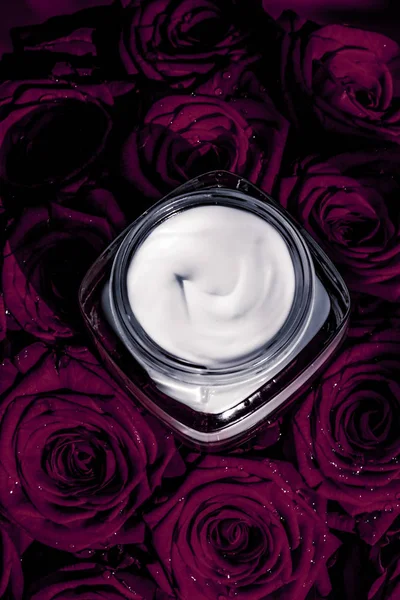 Crema facial hidratante para la piel y flores moradas oscuras, piel de lujo — Foto de Stock