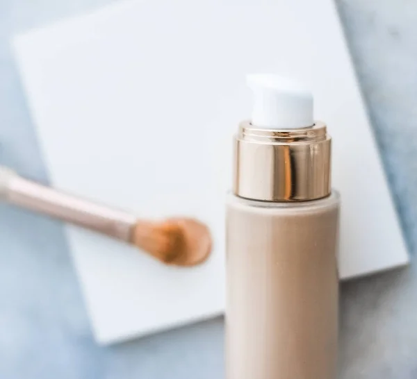 Makeup foundation bottle and contouring brush on marble, make-up — Stock Photo, Image