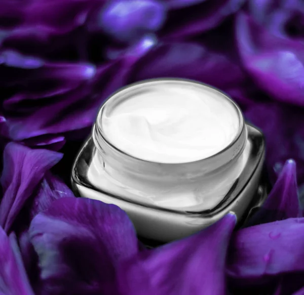 Розкішний крем для обличчя зволожувач для шкіри обличчя на фіолетовій квітці b — стокове фото