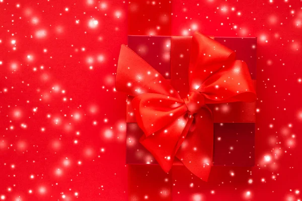 Téli üdülési ajándékok és ragyogó hó piros háttérrel, christm — Stock Fotó